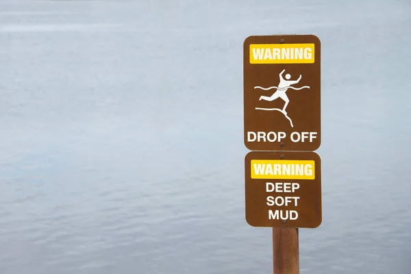 水辺で崖の近くにサインをオフに警告.背中の水 — ストック写真