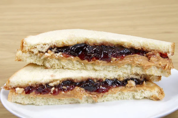 Mantequilla de cacahuete y jalea Sandwich cortado por la mitad servido en el plato en w —  Fotos de Stock