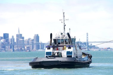 Alameda, Ca - 18 Temmuz 2019: Bir römorkör gemileri iterek veya çekerek hareket ettirir. Ahbra Franco vinç gemisi Grand Canyon State 'in kıç tarafında, geminin limana manevra yapmasına yardım ediyor.