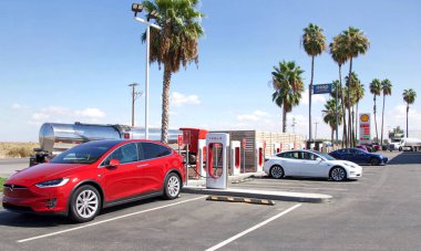 Bakersfield, CA - Sept 28, 2019: Tesla Super Charging station on Stockdale Hwy and 5 fwy. Supercharger stations allow Tesla cars to be fast-charged at the network within an hour. Gas station behind. clipart