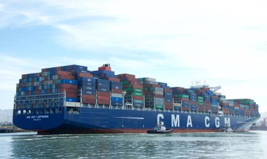 Oakland, CA - 10 Haziran 2020: Kargo gemisi CMA CGM T. JEFFERSON 'a ABD' nin en işlek beşinci limanı Oakland Limanı 'na manevra yapması için yardım eden römorkör.