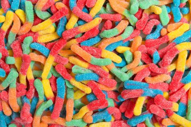 Sour candy gummy worms close up background. Covered in granulated sugar. Flat lay top view from above. clipart