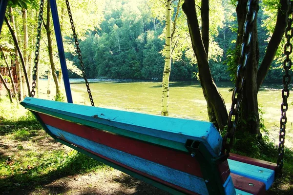 Ława drewniana huśtawka w lesie w pobliżu rzeki — Zdjęcie stockowe