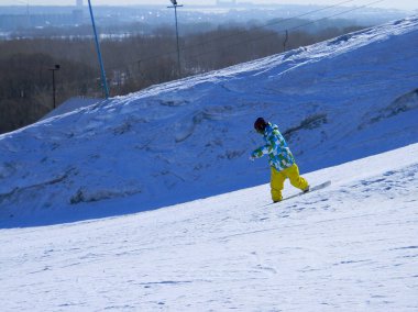 Bir adam bir snowboard üzerinde bir karlı dağdan iner
