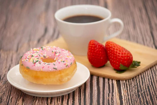 Dessert donuts sugar and hot coffee cups. prepared for relaxation or a party on the wooden table.