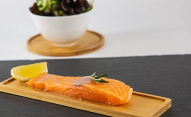 Limonlu ve sebzeli taze somon bifteği. Tahta tabakta diyet yapmak için sağlıklı bir diyet..