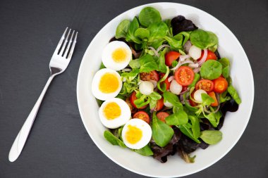 Tatlı domatesle karıştırılmış salata yumurtası, sarımsak turşusu, soğan ve ıspanak her yemek için sağlıklı bir diyettir..