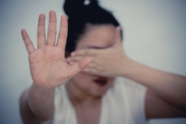 Direniş göstermek veya yüzünü kapatmak için elini kaldıran bir kadının görüntüsü ve beyaz arka planda kadınlara yönelik Kavram Şiddeti 'nin şiddetine son vermek isteyen bir kadın..