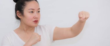 Beyaz arka planda kadınlara yönelik şiddeti durdurmak isteyen ve direnç göstermek için elini kaldıran bir kadının resmi..