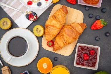 Kahvaltıda kahve, tereyağlı kruvasan, mısır gevreği, fincanda süt, çilek, ahududu, kivi ve kahvaltı masasında taze portakal suyu ile servis edilir..