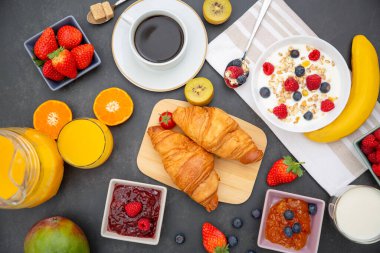 Kahvaltıda kahve, tereyağlı kruvasan, mısır gevreği, fincanda süt, çilek, ahududu, kivi ve kahvaltı masasında taze portakal suyu ile servis edilir..