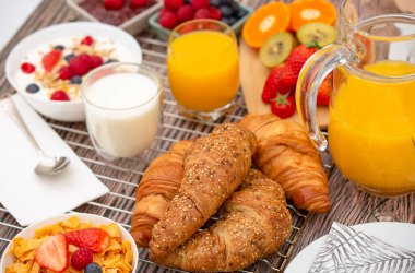 Kahvaltıda meyveli yoğurt, tereyağlı kruvasan, mısır gevreği, fincanda süt, çilek, ahududu, kivi ve kahvaltı masasında taze portakal suyu ile servis edilir.