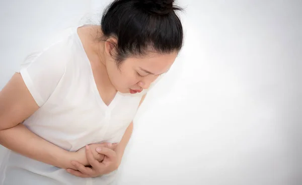 胃の痛みのために彼女の胃の中に彼女の手を保持しているアジアの女性のイメージ 胃の痛みのために 白い背景に食品由来の感染症を持っています — ストック写真