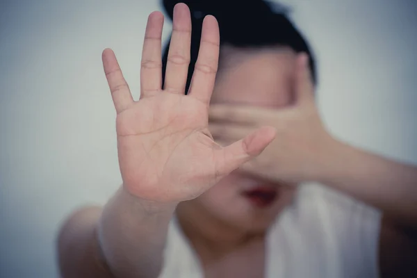 The image of a woman raising her hand to prohibit or cover her face to show resistance and want to stop in the violence of Concept Violence against women in a white background.