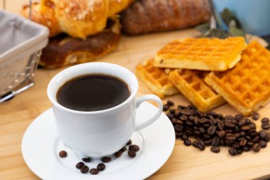 Kahvaltıda yanında siyah kahve, tereyağlı kruvasan, çikolatalı ekmek, buğday ekmeği ve her gün kahvaltı masasındaki ahşap tepside şekerli kremalı ekmek vardı.