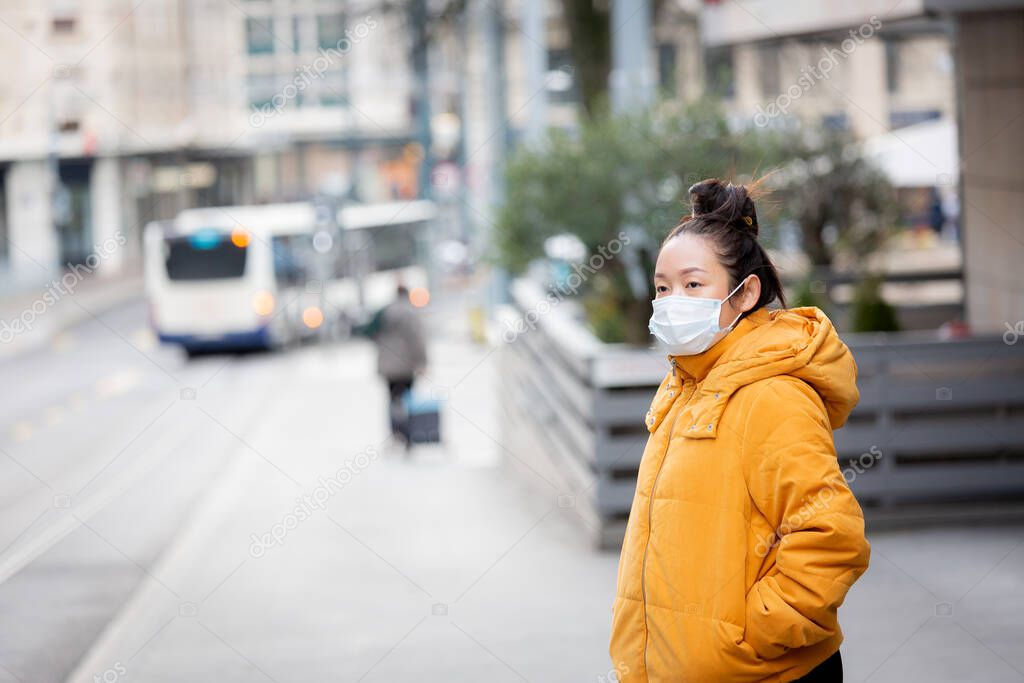 The image of a young Asian woman wearing a mask to prevent germs, toxic fumes, and dust. Prevention of bacterial infection in the air around the streets and gardens.