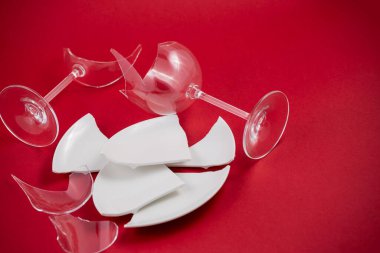 Kırık tabak ya da kırmızı arka planda kırık su camı mutfaktaki kaza konsepti vücut ve evin içindeki çocuklar için tehlikelidir..