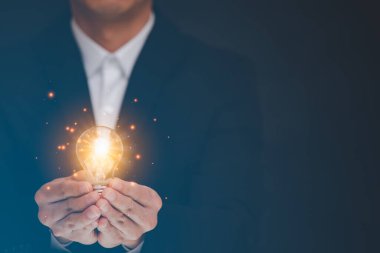 İş adamı, ampulü grafik ekranı, Teknoloji İşlem Sistemi İş Konseptinin Ekran Simgesi 'nde tutuyor.