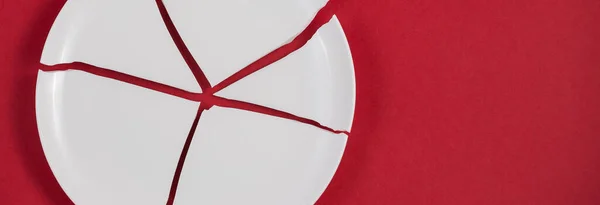 Broken Plate or broken water glass on the on the red background The concept of accidents in the kitchen is dangerous for the body and young children inside the house.