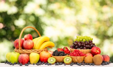 Muz, kivi, üzüm, ahududu, böğürtlen ve böğürtlenli C vitamini ile ahşap sepetteki sağlıklı meyve grubu..