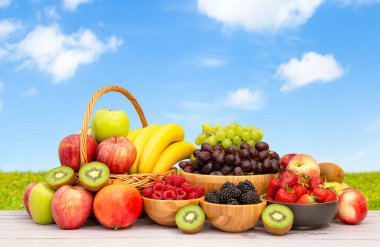 Muz, kivi, üzüm, ahududu, böğürtlen ve böğürtlenli C vitamini ile ahşap sepetteki sağlıklı meyve grubu..