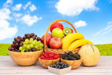 Muz, kivi, üzüm, ahududu, böğürtlen ve böğürtlenli C vitamini ile ahşap sepetteki sağlıklı meyve grubu..