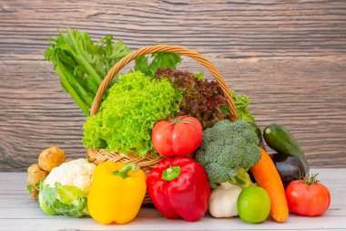 Sağlıklı bir grup, salata, domates, havuç, karnabahar ve zencefilli C vitamini ile ahşap sepetteki taze sebzeler, doğanın arka planındaki vücut ve diyet yemekleri için iyidir..
