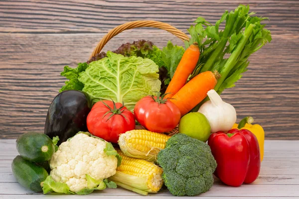 Group Healthy assorted fresh vegetable in a wooden basket, With vitamins c from salad, tomato, carrot, Cauliflower, and ginger, Is good for the body and diet food on  table in the nature  background.