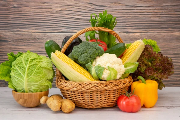 Group Healthy assorted fresh vegetable in a wooden basket, With vitamins c from salad, tomato, carrot, Cauliflower, and ginger, Is good for the body and diet food on  table in the nature  background.