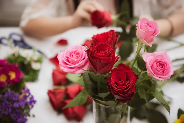 Woman Preparing to trim red and pink roses and beautiful flower arrangements in the home, flower arrangements with vase for gift-giving for Valentine\'s Day and Business in the family on the on table