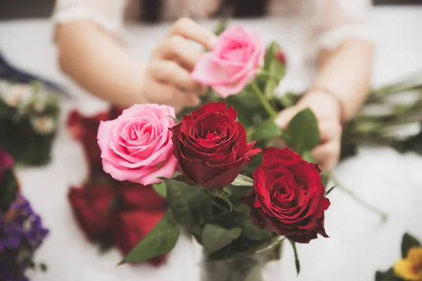 stock image Woman Preparing to trim red and pink roses and beautiful flower arrangements in the home, flower arrangements with vase for gift-giving for Valentine's Day and Business in the family on the on table