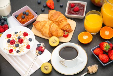 Kahvaltıda kahve, tereyağlı kruvasan, mısır gevreği, fincanda süt, çilek, ahududu, kivi ve kahvaltı masasında taze portakal suyu ile servis edilir..