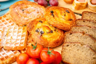 Kahvaltıda yanında mısır ekmeği, kuru üzüm, muz ekmeği, sosis, tavuk sosisi, mısır gevreği kahvaltılık gevrek ve her gün kahvaltı masasında meyve ile servis edilir.