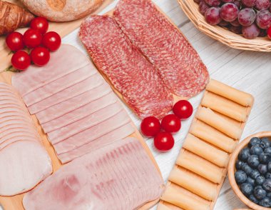 Sabah kahvaltı masada kruvasan ekmeği, kruvasan gevreği, pastırma, jambon, peynir, marul, fasulye, mısır gevreği, sağlıklı kahvaltı için meyve ve fotokopi alanı ile servis edilir.