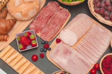 Sabah kahvaltı masada kruvasan ekmeği, kruvasan gevreği, pastırma, jambon, peynir, marul, fasulye, mısır gevreği, sağlıklı kahvaltı için meyve ve fotokopi alanı ile servis edilir.