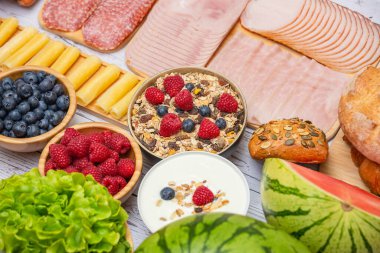 Sabah kahvaltısı sebze, kruvasan ekmeği, jambon, peynir, marul, fasulye, mısır gevreği ve meyveli olsun.