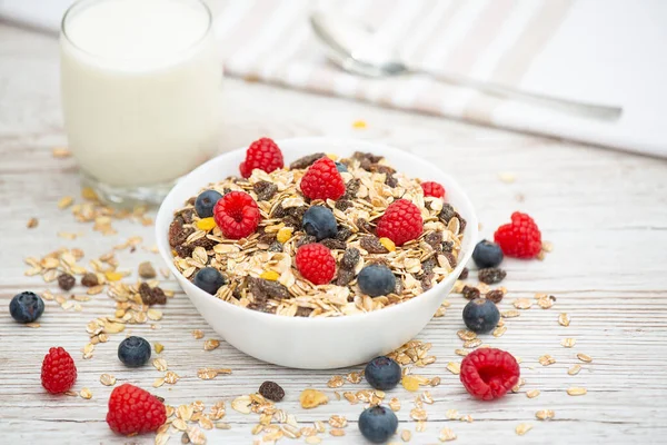 Kahvaltıda mısır gevreği, tam tahıl ve fincanda süt, çilek, böğürtlen, ahududu, ahududu, ahşap masada Kivi, diyet yemeği veya sabahları sağlıklı yemekle servis edilir..