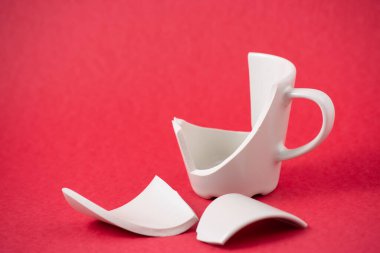 Kırık tabak, tabak ya da kırmızı arka planda kırık su bardağı. Mutfaktaki kaza kavramı, evin içindeki beden ve çocuklar için tehlikelidir..