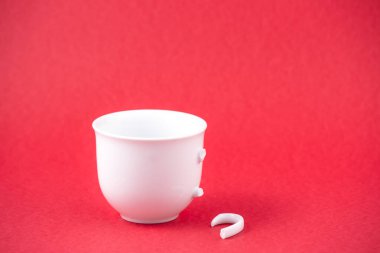 Kırık tabak, tabak ya da kırmızı arka planda kırık su bardağı. Mutfaktaki kaza kavramı, evin içindeki beden ve çocuklar için tehlikelidir..