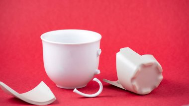 Kırık tabak, tabak ya da kırmızı arka planda kırık su bardağı. Mutfaktaki kaza kavramı, evin içindeki beden ve çocuklar için tehlikelidir..