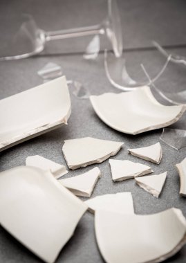 Mutfağın zemininde kırık tabaklar ya da kırık su bardakları. Mutfaktaki kaza kavramı, evin içindeki beden ve çocuklar için tehlikelidir..