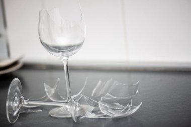 Mutfağın zemininde kırık tabaklar ya da kırık su bardakları. Mutfaktaki kaza kavramı, evin içindeki beden ve çocuklar için tehlikelidir..