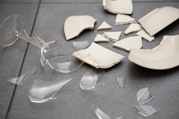 Broken Plate or broken water glass on the on the floor in the kitchen The concept of accidents in the kitchen is dangerous for the body and young children inside the house.