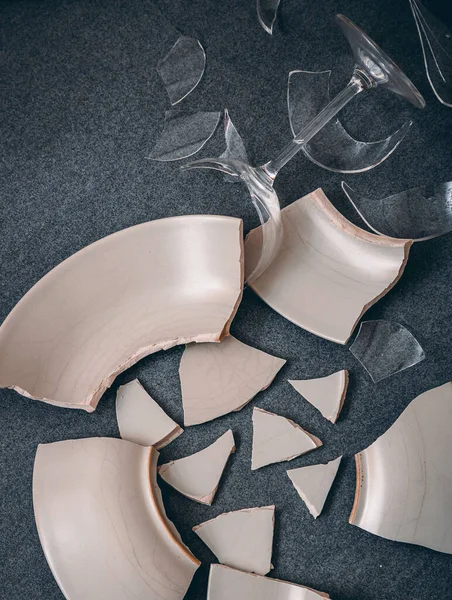 Mutfağın zemininde kırık tabaklar ya da kırık su bardakları. Mutfaktaki kaza kavramı, evin içindeki beden ve çocuklar için tehlikelidir..