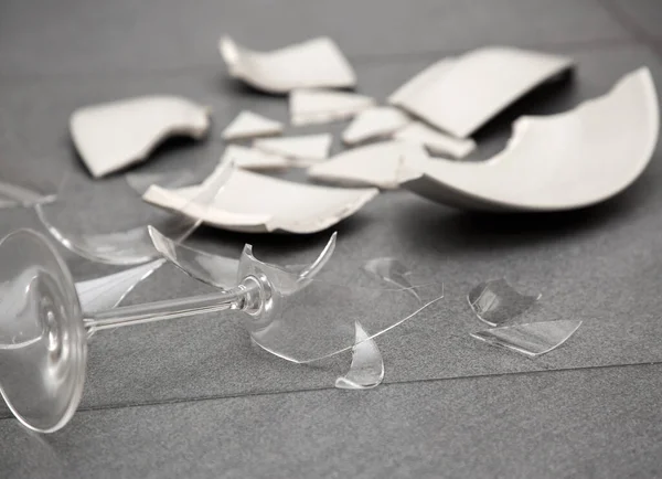 Mutfağın zemininde kırık tabaklar ya da kırık su bardakları. Mutfaktaki kaza kavramı, evin içindeki beden ve çocuklar için tehlikelidir..