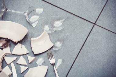 Broken Plate or broken water glass on the on the floor in the kitchen The concept of accidents in the kitchen is dangerous for the body and young children inside the house. clipart