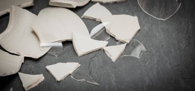 Mutfağın zemininde kırık tabaklar ya da kırık su bardakları. Mutfaktaki kaza kavramı, evin içindeki beden ve çocuklar için tehlikelidir..