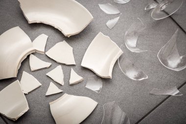 Mutfağın zemininde kırık tabaklar ya da kırık su bardakları. Mutfaktaki kaza kavramı, evin içindeki beden ve çocuklar için tehlikelidir..