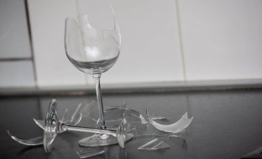 Mutfağın zemininde kırık tabaklar ya da kırık su bardakları. Mutfaktaki kaza kavramı, evin içindeki beden ve çocuklar için tehlikelidir..