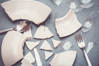 Mutfağın zemininde kırık tabaklar ya da kırık su bardakları. Mutfaktaki kaza kavramı, evin içindeki beden ve çocuklar için tehlikelidir..